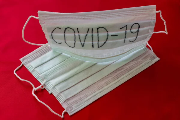 Topeng Medis Dengan Tulisan Covid Dengan Latar Belakang Merah — Stok Foto
