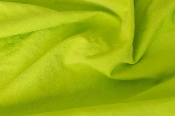 wrinkled green cotton material. texture or background