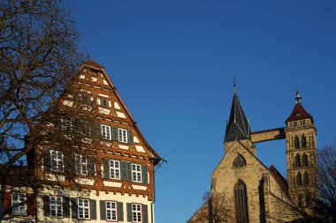 Vordergrund ein history of history Fachwerkhaus das ein Museum beherbergt im Hintergrund die Stadtkirche St. Dionys in Esslingen.