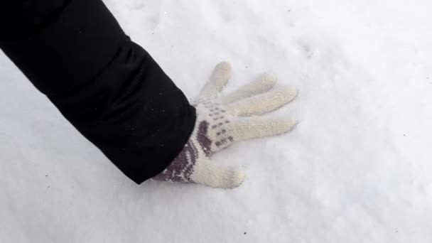 Рукавичка стискає білий сніг — стокове відео