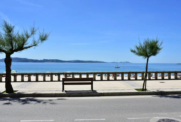 石の手すりと木製のベンチと遊歩道からのシルガービーチの眺め ポンテベドラ州のリアス バイシャス スペインのサンクセクソ2019年5月12日 — ストック写真