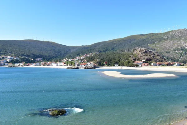 Small coastal village with beach, mountain and clear water with turquoise colour. Ezaro, A Coruna Province, Spain.