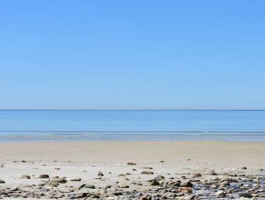 Kayalıklı sahil, küçük dalgalar, mavi deniz ve açık gökyüzü. Galiçya, İspanya.