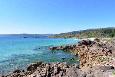 Kumsalı, turkuaz suyu ve mavi gökyüzü olan körfez. Kayalardan bak. San Pedro Plajı, O Pindo Plajı olarak da bilinir. Carnota, Coruna, Galiçya, İspanya.