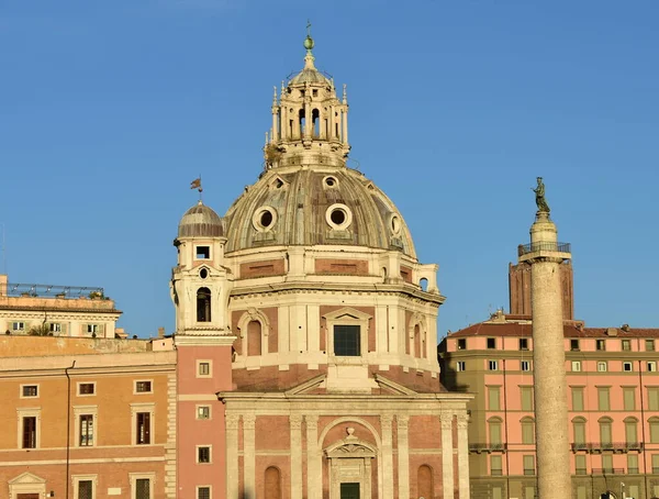Colonna Traiana veya Trajan Column ve Chiesa del Santissimo Nome di Maria al Foro Traiano gün batımı ışığı ve mavi gökyüzü. Roma, İtalya.