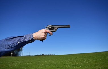 Elinde 44 ya da 45 kalibrelik bir tabanca tutan bir adam..