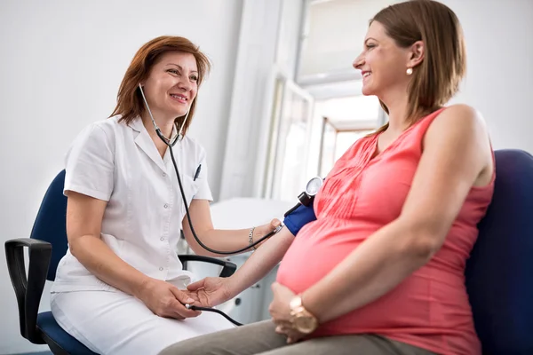Enfermeira medir a pressão da mulher grávida — Fotografia de Stock