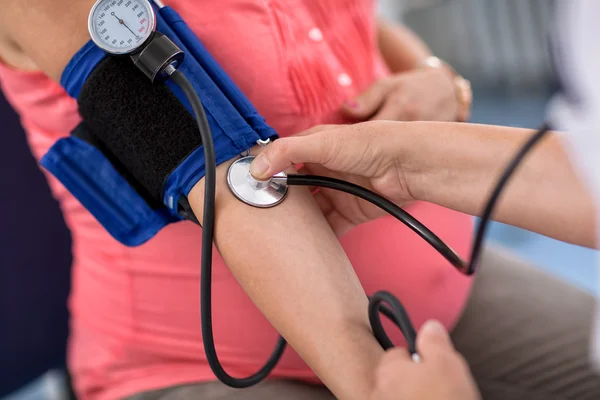 Nurse checking blood pressure of a pregnant woman, close up — Stock Photo, Image