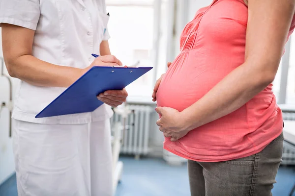 Pielęgniarka, sprawdzanie wagi w ciąży kobiety — Zdjęcie stockowe