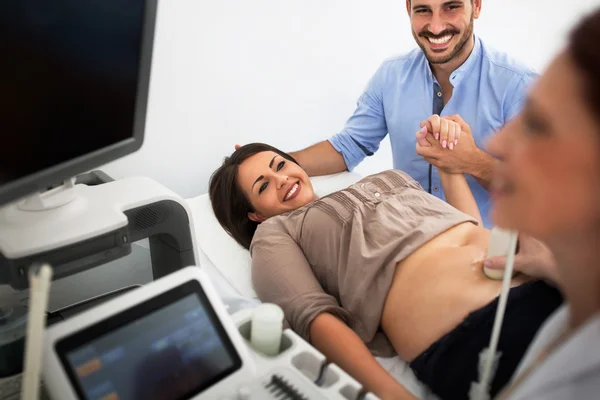 Husband and wife in a clinic, ultrasound exam — Stock fotografie