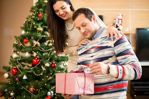 Couple amoureux ouverture cadeaux près de l'arbre de Noël — Photo