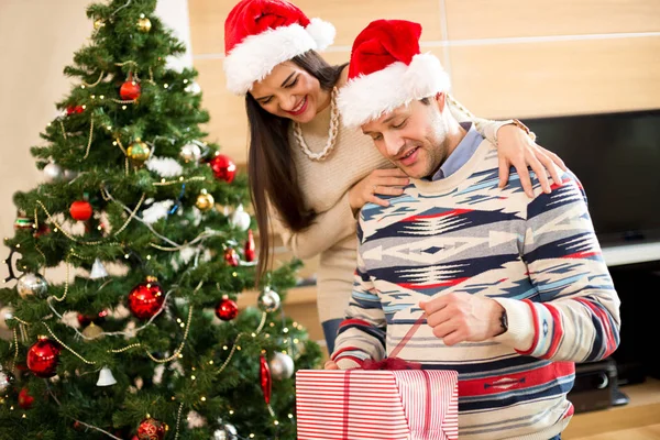 Couple amoureux ouverture cadeaux près de l'arbre de Noël — Photo