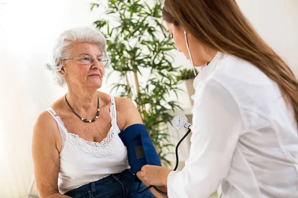 Dokter Perempuan Memeriksa Tekanan Darah Perempuan Senior — Stok Foto