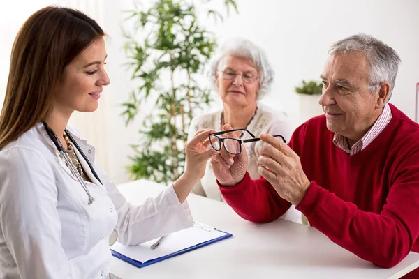 Dokter ofthalmologist memberikan kacamata untuk pasien setelah tes mata — Stok Foto