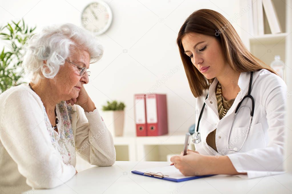 Doctor writes recipe for senior woman patient