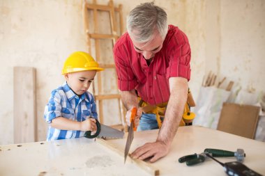 Dede ve torunu ahşap bir garaj ile çalışma