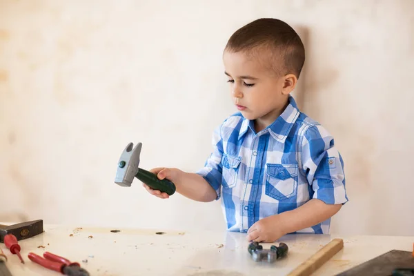 Schattige jongen werken met hout in werkplaats — Stockfoto