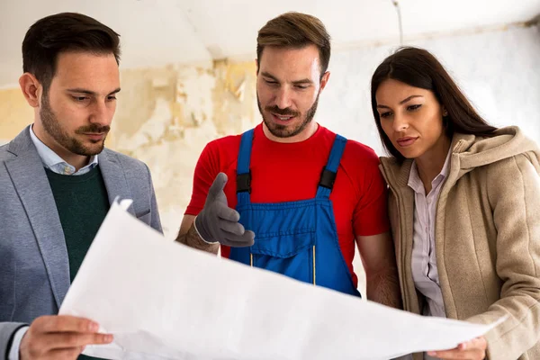 Casal jovem mostra para construtor problema faz-tudo sobre renovações — Fotografia de Stock