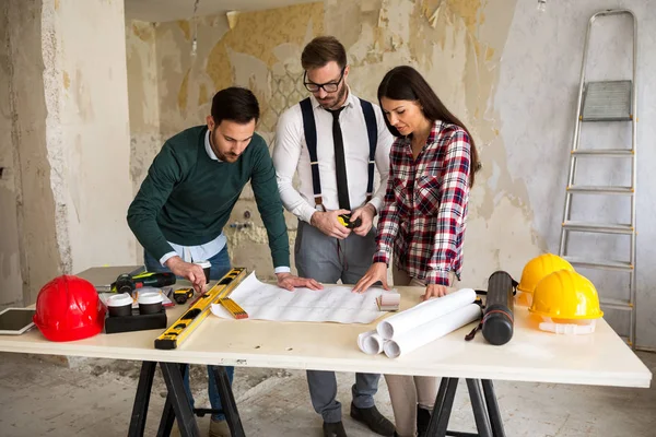 Trabajo en equipo. Tres jóvenes arquitectos trabajando en un proyecto — Foto de Stock