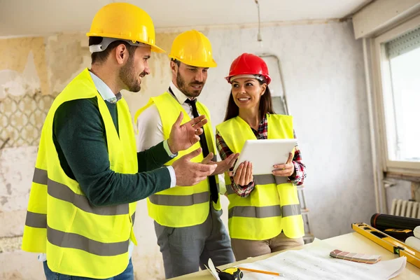 Groupe de jeunes arhitects avec tablette sur chantier — Photo