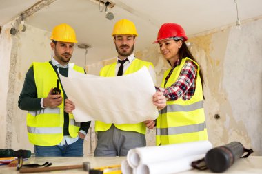 Üç arhitects birlikte çalışan inşaat proje sitesi