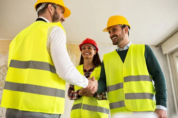 Des ingénieurs se serrent la main sur le chantier — Photo