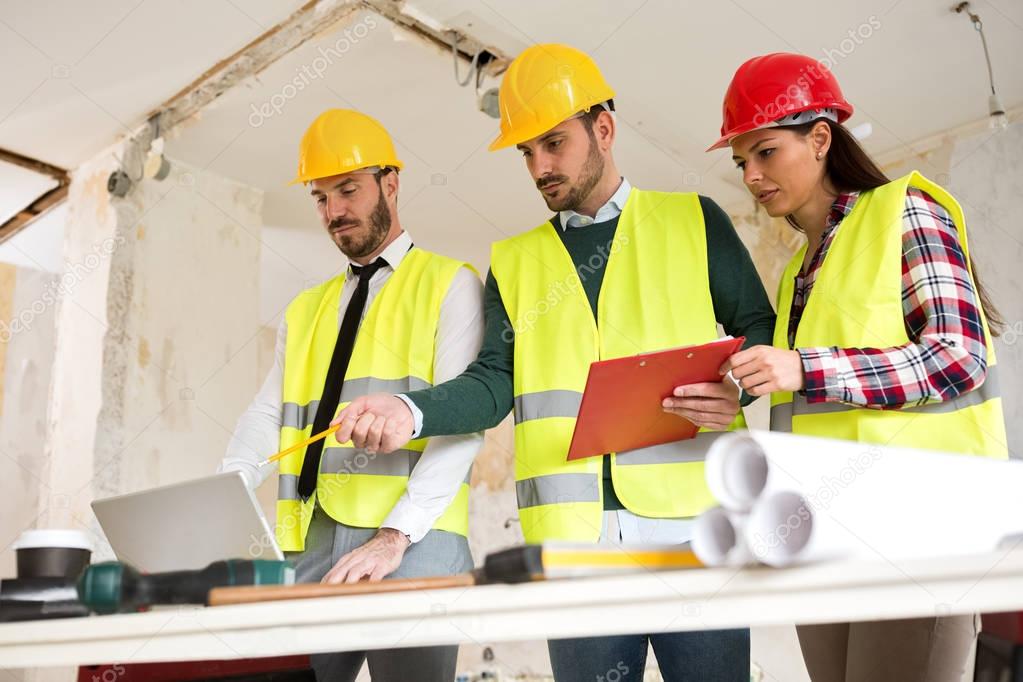 Three arhitects working together on construction site project