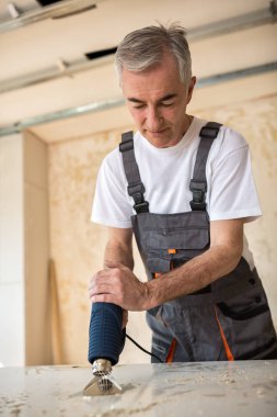 Kapıyı bir marangoz atölyesinde işçi onarır