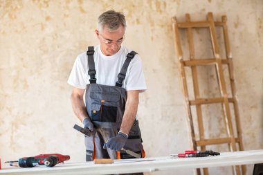 Marangoz bir atölyede çalışıyor