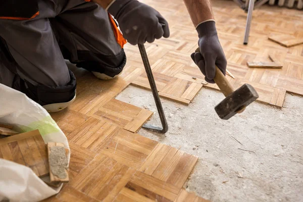 Trabajador elimina viejo fparquet, la renovación de casa —  Fotos de Stock