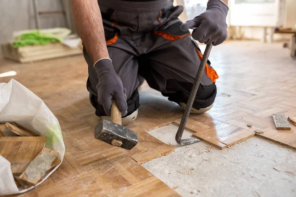Trabajador elimina viejo fparquet, la renovación de casa —  Fotos de Stock