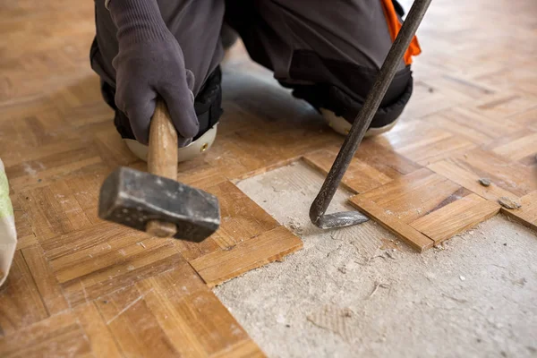 Trabajador elimina viejo fparquet, la renovación de casa —  Fotos de Stock