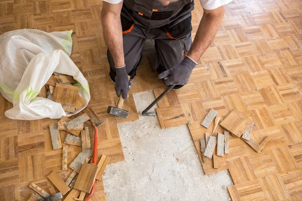 Trabalhador remove fparquet velho, casa de renovação — Fotografia de Stock