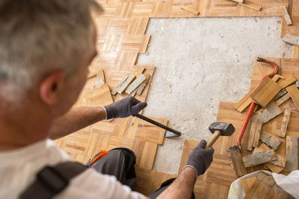 Trabajador elimina viejo fparquet, la renovación de casa —  Fotos de Stock