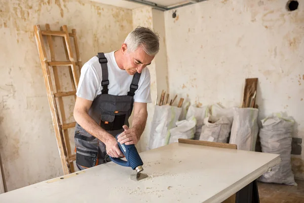 Trabajador repara la puerta en un taller de carpintería — Foto de Stock