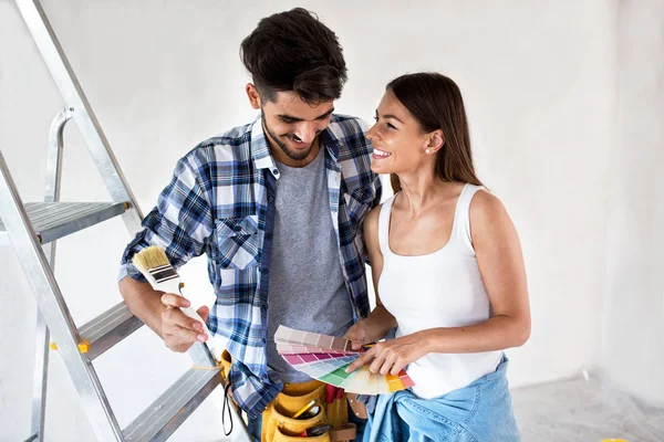 Молода пара вибирає кольори для фарбування свого нового будинку — стокове фото