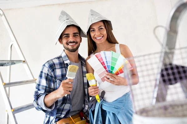 Estamos listos para la pintura, pareja joven elegir colores para el nuevo — Foto de Stock