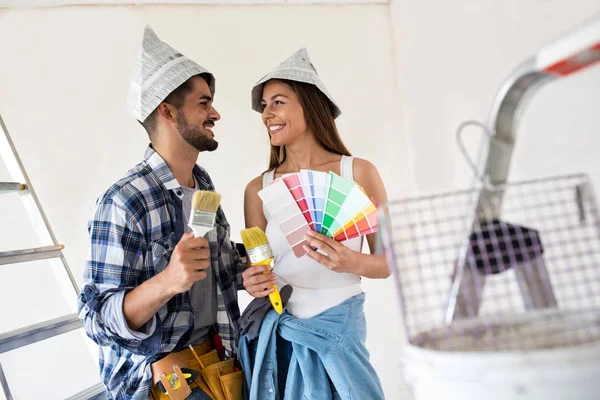 Funny young couple holding brush and color palette, preparation — Stock Photo, Image
