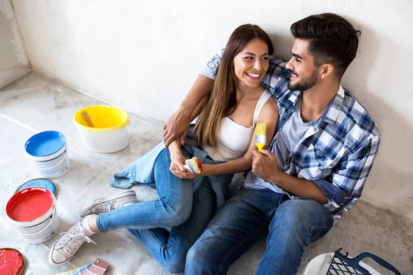 Feliz jovem casal relaxante após a pintura — Fotografia de Stock