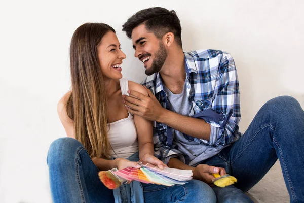 Sonriendo atractiva pareja divirtiéndose mientras la renovación de casa — Foto de Stock