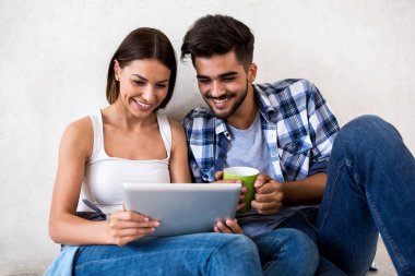 Zevk ve tablet kullanırken gülümseyen