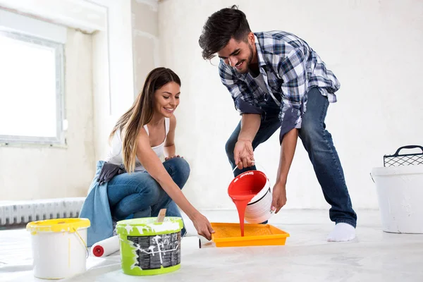 Preciosa pareja sonriente pintando nuevo hogar, renovación de la casa nueva — Foto de Stock