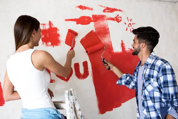 Preciosa sonrisa feliz pareja pintura nuevo hogar — Foto de Stock