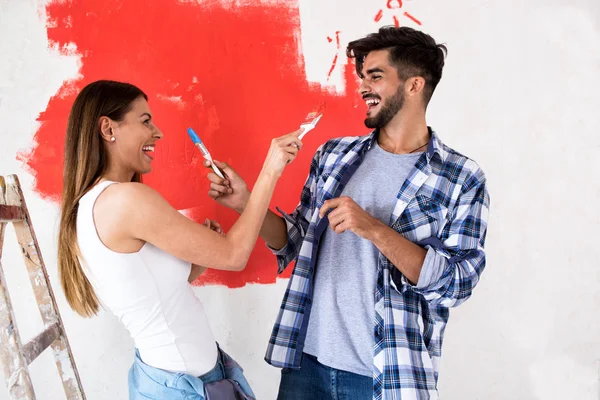 Sonriendo divertida pareja haciendo pintura — Foto de Stock
