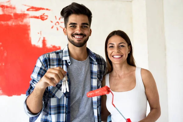 若いカップルは、彼らの新しいアパートを飾る。彼らは絵画とハヴィ — ストック写真