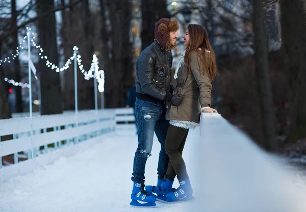 Happy couple, girl and boy ice skating outdoor at rink — Stock Photo, Image