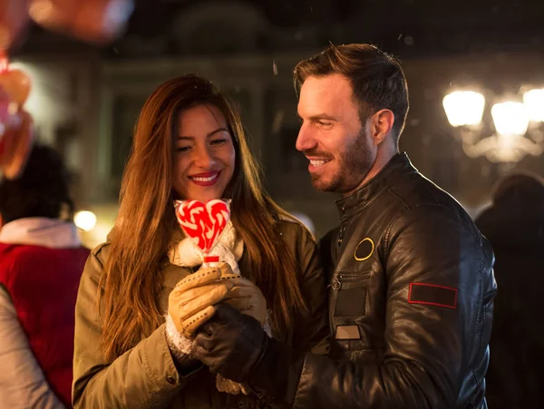 Young smiling man in love gives sweets hearth — Stock Photo, Image