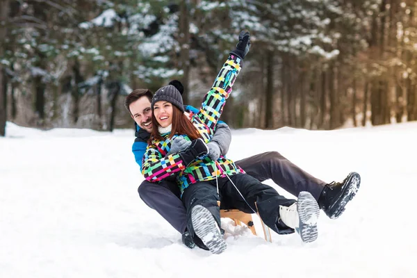 Smiling and happy couple enjoy in sledding — Stock Photo, Image