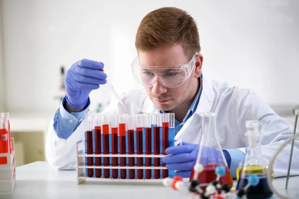 Skoncentrowane chemik Trzymając pipetę i pracę w laboratorium — Zdjęcie stockowe