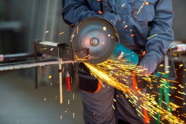Öğütücüyle metal kesen bir işçi.